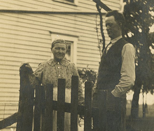photograph of Wilhelmine Louise (Fiegenbaum) Starkebaum and Wilhelm Friedrich Fiegenbaum standing in the side yard by a picket fence